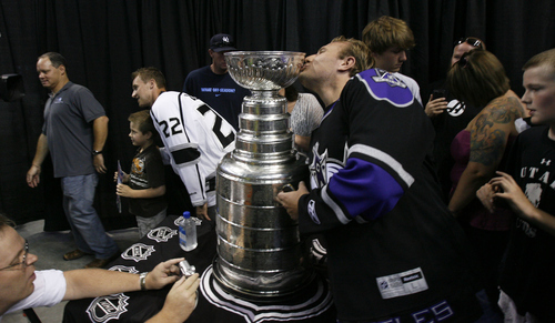 Francisco Kjolseth  |  The Salt Lake Tribune
Michael Weaver of Kaysville sneaks in a kiss on the Stanley Cup as Trevor Lewis, who played hockey for Brighton High School, brings the Stanley Cup home for a day as a member of the NHL champion Los Angeles Kings. Thousands of fans lined up at the Maverik Center in West Valley City on Thursday, August 30, 2012, for a chance to pose for a picture with Lewis and the Cup.
