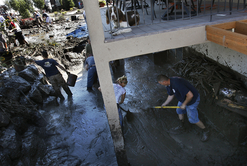 Scott Sommerdorf  |  The Salt Lake Tribune             
As a dog looks on, volunteers work together to shovel out the mud around a home on Weatherby Drive. A large group of neighbors and other volunteers pitch in to help the homeowners affected by the flood near the intersection of Apaloosa and Weatherby Drives in Saratoga Springs, Sunday, September 2, 2012.