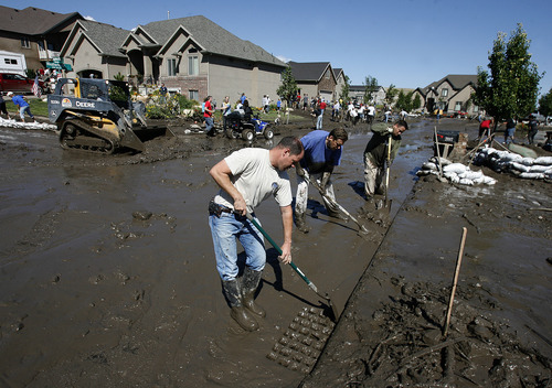 Scott Sommerdorf  |  The Salt Lake Tribune             
Neighbors and other volunteers work to direct mud into the storm drains  near the intersection of Apaloosa and Weatherby Drives in Saratoga Springs, Sunday, September 2, 2012.