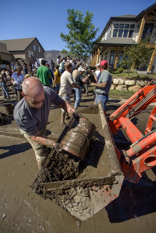 Douglas C. Pizac  |  Special to The Salt Lake Tribune

Mike Follett empties muddy water from the basement during the cleanup of a home flooded by hillside run off Monday, Sept. 3, 2012, in Saratoga Springs, Utah. Volunteers formed two bucket brigades to empty a basement full of muck.