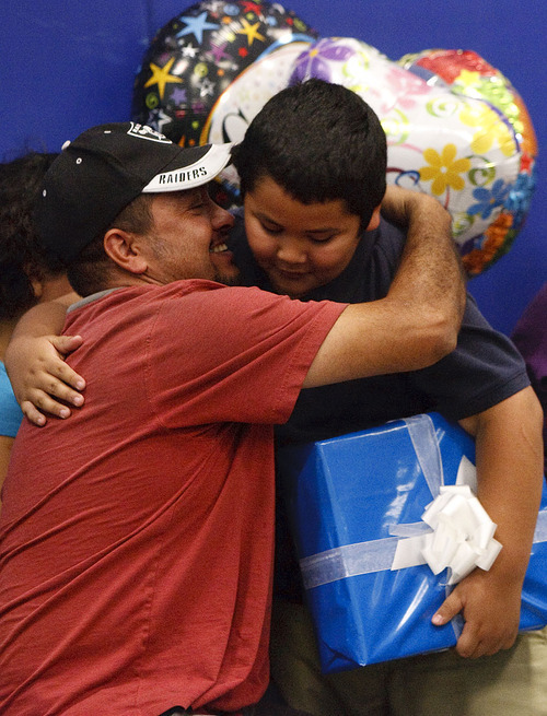 Leah Hogsten  |  The Salt Lake Tribune
Edison Elementary third-grader Abraham Vega receives a hug and a kiss from his father, Jesus Vega, on Thursday after Abraham was given a  netbook computer from Comcast for most improved language arts score in his class. Edison Elementary students learned more about the benefits of connecting to the Internet with hands-on Internet training, an introduction to accessing and reading e-books online and how the use of multi-faceted document cameras donated to the school by Comcast will help improve the education experience for students and teachers.