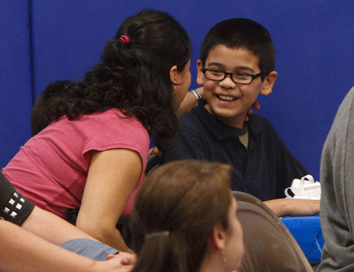 Leah Hogsten  |  The Salt Lake Tribune
Edison Elementary fifth-grader Oscar Quintanar receives a hug and a kiss from his mother, Angelina Quintanar, after Oscar was given a netbook computer from Comcast for most improved language arts score in his class. Edison Elementary students learned Thursday about the benefits of connecting to the Internet with hands-on Internet training, an introduction to accessing and reading e-books online and how the use of multi-faceted document cameras donated to the school by Comcast will help improve the education experience for students and teachers.