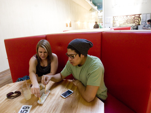 Kim Raff | The Salt Lake Tribune
(left) Emily Nichols and Stefan Sanchez share a plate of fries in a booth at CO2 Cafe, a newly opened cafe in a renovated building on Main Street in Salt Lake City, Utah on September 8, 2012. Mike Wirthlin, who owns the cafe with his wife Niki Nichols, is a former analyst for the CIA who came to Salt Lake City to open a gathering place for the community.