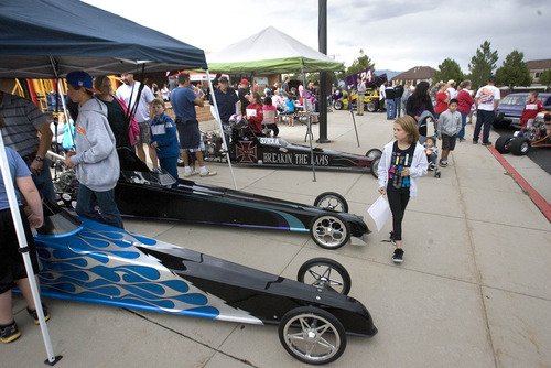 Paul Fraughton | Salt Lake Tribune
Youngsters and their families look over junior race cars on display at Silver Hills Elementary School in Kearns. The event , sponsored by the school's PTA, featured  race drivers from Rocky Mountain Raceway  of all ages who  brought their  race cars to the school so kids could get an up close experience with the unique machines.
 Monday, September 10, 2012