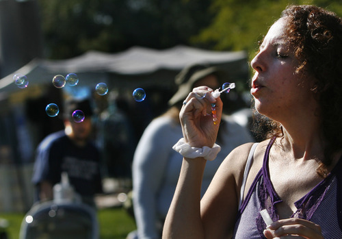 Scott Sommerdorf  |  The Salt Lake Tribune             
Michelle Quintana blows bubbles to try to generate interest in the Crone's Hollow booth at the Annual Pagan Pride Day at Murray Park, Sunday, September 9, 2012.