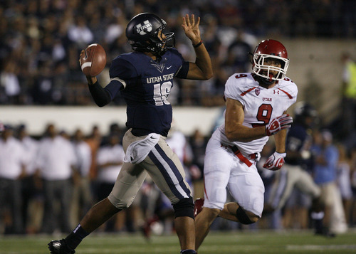 Scott Sommerdorf  |  The Salt Lake Tribune             
USU QB Chuckie Keeton throws while being watched by Utah LB Trevor Reilly during second half play. The USU Aggies beat Utah 27-20 in OT, Friday, September 7, 2012.