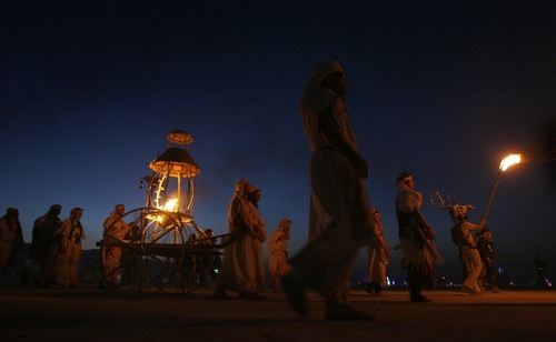 Rick Egan  | The Salt Lake Tribune 

The Lamplighters procession marches along the Promenade, towards the Burning Man, carrying the cauldron with the flame that will start the festivities at Burning Man 2012, in the Black Rock Desert, NV, September 1, 2012.