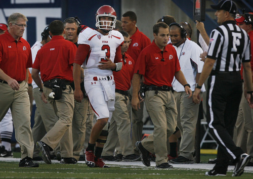 Scott Sommerdorf  |  The Salt Lake Tribune             
Utah QB Jordan Wynn heads to the locker room holding his previously injured left shoulder as head coach Kyle Whittingham gets a report from assistants in the background during the game against Utah State on Friday, Sept. 7, 2012.
