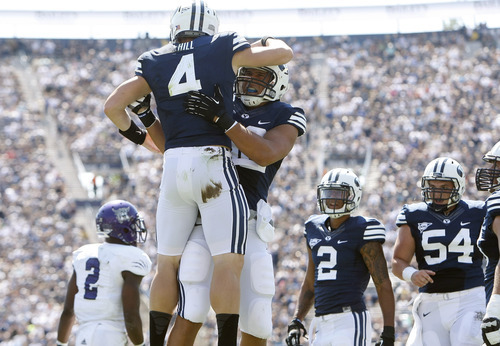 Chris Detrick  |  The Salt Lake Tribune
Brigham Young Cougars quarterback Taysom Hill (4) and Brigham Young Cougars tight end Kaneakua Friel (82) celebrate after Hill scored a touchdown during the first half of the game against Weber State at LaVell Edwards Stadium Saturday September 8, 2012. BYU is winning the game 21-0.