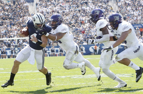 Chris Detrick  |  The Salt Lake Tribune
Brigham Young Cougars quarterback Taysom Hill (4) scores a touchdown while being face-masked by Weber State Wildcats linebacker Anthony Morales (44) during the first half of the game against Weber State at LaVell Edwards Stadium Saturday September 8, 2012. BYU is winning the game 21-0.