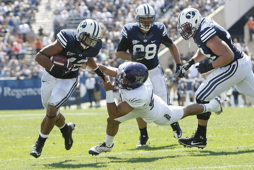 Chris Detrick  |  The Salt Lake Tribune
Brigham Young Cougars running back Michael Alisa (42) runs for a touchdown past Weber State Wildcats linebacker Roman Valenzuela (50) during the first half of the game against Weber State at LaVell Edwards Stadium Saturday September 8, 2012. BYU is winning the game 21-0.