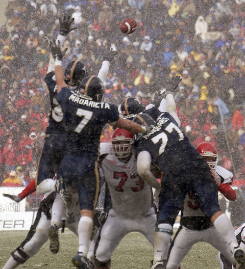 Provo - BYU defenders leap up, unsuccessfully attempting to block Utah's only score of the game, a field goal. BYU vs. Utah football Saturday at LaVell Edwards Stadium.
Photo by Trent Nelson/The Salt Lake Tribune; 11/22/2003