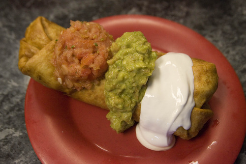 Paul Fraughton | The Salt Lake Tribune
A giant chimmichanga with sour cream, salsa and guacamole crowds the plate at Mountain West Burrito in Provo.