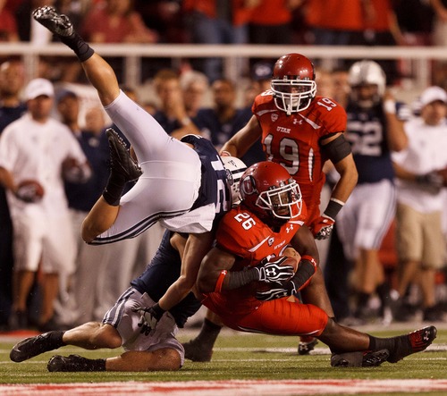 Trent Nelson  |  The Salt Lake Tribune
BYU quarterback Riley Nelson andwide receiver JD Falslev (12) tackle Utah defensive back Ryan Lacy (26) after a third-quarter interception during the game in Salt Lake City on Saturday, Sept. 15, 2012.