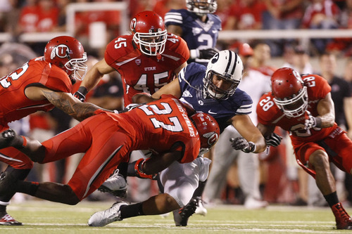 Chris Detrick  |  The Salt Lake Tribune
Brigham Young Cougars tight end Kaneakua Friel (82) is tackled by Utah Utes linebacker LT Filiaga (42) Utah Utes defensive back Tyron Morris-Edwards (27) Utah Utes linebacker Boo Andersen (45) and Utah Utes defensive back Reggie Topps (28) during the first half of against BYU at Rice-Eccles Stadium Saturday September 15, 2012.  The score is 7-7 at halftime.