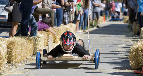 Paul Fraughton | The Salt Lake Tribune
Chris Fedor, a Rowland Hall sophomore, guides his team's gravity car through a hay bale lined course on the sidewalk south of the school. Piloting the car in a prone position helped the car finish with the fastest time for a sophomore car. The cars, built by the students earlier in the day, were part of a science lesson dealing with potential and kinetic energy. The event was part of the school's 