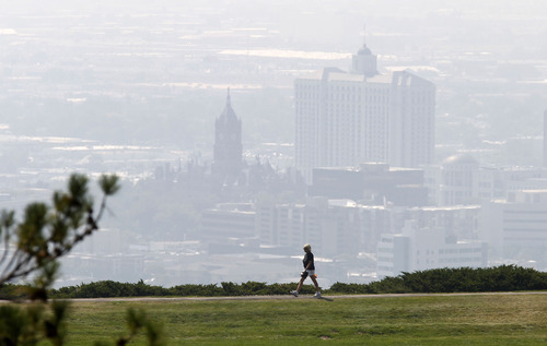 Al Hartmann  |  The Salt Lake Tribune
Walker at 11th Avenue Park stands out above Salt Lake's smokey downtown Tuesday afternoon.  Low visibility and haze is smoke from wildfires in Idaho.  It was a red air day along the Wasatch front.