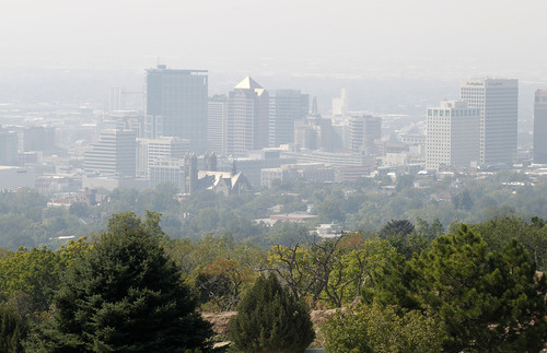 Al Hartmann  |  The Salt Lake Tribune
Downtown Salt Lake City skyline is obscured by smoke seen from a vantage point at 11th Avenue Park just a  couple miles to the north Tuesday afternoon. Low visibility and haze is smoke from wildfires in Idaho drifting down into the state.  It was a red air day along the Wasatch front.