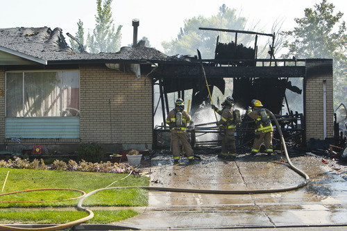Chris Detrick  |  The Salt Lake Tribune
Unified Fire fighters work at putting out hot spots at a house fire at 3785 West Dimrall Drive Thursday September 20, 2012.