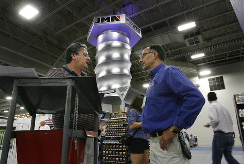 Scott Sommerdorf  |  The Salt Lake Tribune             
Mike McDermott, left, a Tru Value store owner from Minerva, Ohio, speaks with Genie door salesman Terry Painley with a giant rotating screw behind them at the Tru Value trade show at the Salt Palace, Friday, September 21, 2012. True Value Hardware stores are holding one of their big twice-annual trade shows at the Salt Palace with vendors showing all sorts of new hardware that will soon be available.