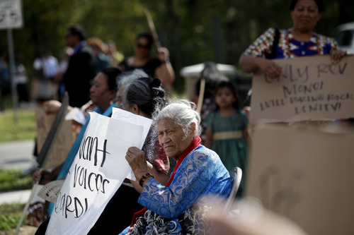Ashley Detrick  |  The Salt Lake Tribune
Tae Houma holds a sign with dozens of other members of the Tongan United Methodist Church during a protest outside the church on Sunday September 23, 2012.  Members of the West Valley City church protested the temporary removal of their pastor, Rev. Havili Mone. The members are upset that they were not given an explanation for the move and that the replacement pastor locked members out of the church last week.