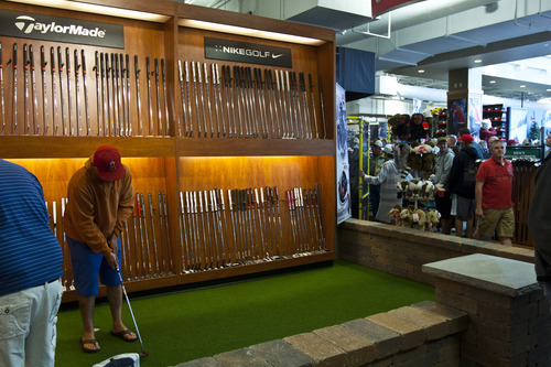 Chris Detrick  |  The Salt Lake Tribune
Customers test out golf putters at Scheels Saturday September 29, 2012. Scheels opened its 220,000-square-foot mega-sporting goods store in Sandy. Featuring a 16-car Ferris wheel rising toward a skylight, a 16,000-gallon double-arched salt water aquarium, a boating department, game centers and a focus on fashionable apparel, the store is meant to be a fun destination, said Dan Hermanson, an assistant store leader.