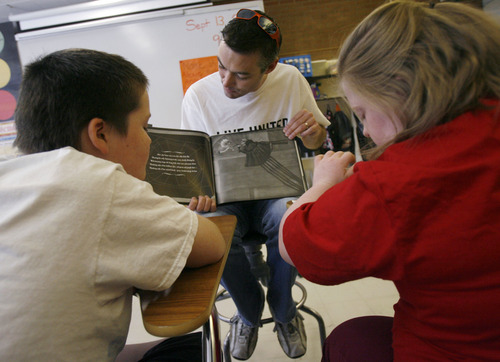 Francisco Kjolseth  |  The Salt Lake Tribune
Chad Winter, center, reads a book for 12-year-olds Nathan Perkins, left, and Angel Funk in Ms. Lisa Seipert's special needs class at Kearns Junior High on Thursday, September 13, 2012. Volunteers from 3M Health Information Systems and Holland & Hart helped clean up the grounds and helped tutor students in math and reading as part of the state-wide United Day of Caring.