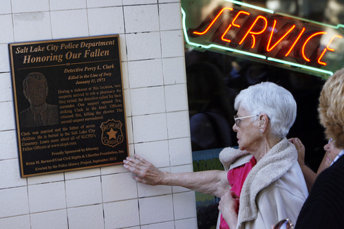 Francisco Kjolseth  |  The Salt Lake Tribune
Maurine Clark touches the plaque honoring her husband's service as a detective before he was shot and killed during an armed robbery 39 years ago. The Salt Lake Police Department gathered at 564 E. Third Ave. in Salt Lake City on Thursday, October 4, 2012, to dedicate the plaque at the Avenues Bistro on Third, which used to be a pharmacy back in 1973 where an armed robbery led to his death.