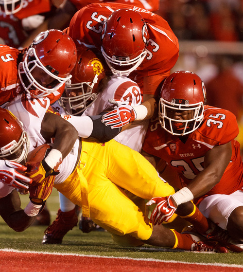 Trent Nelson  |  The Salt Lake Tribune
Utah linebacker Trevor Reilly (9), defensive tackle Niasi Leota (93) and linebacker Reshawn Hooker (35) are unable to stop USC's Silas Redd from scoring during a game Oct. 4, 2012 at Rice-Eccles Stadium in Salt Lake City.
