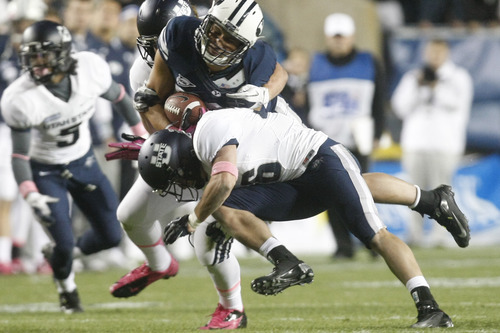 Chris Detrick  |  The Salt Lake Tribune
Brigham Young Cougars tight end Kaneakua Friel (82) is tackled by Utah State Aggies safety McKade Brady (36) and Utah State Aggies linebacker Jake Doughty (51) during the first half of the game at LaVell Edwards Stadium Friday October 5, 2012. BYU is winning the game 6-3.