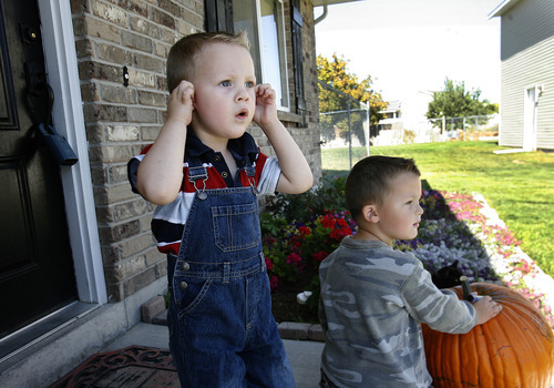 Scott Sommerdorf  |  The Salt Lake Tribune             
Damien Cook, left, reacts to the loud noise of the UPS man as he turns around his truck on their street while on the porch with his older brother Christian, Monday, October 1, 2012.