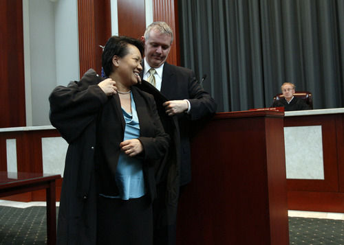 Francisco Kjolseth  |  The Salt Lake Tribune
Andrew Stone performs the robing ceremony for his wife Judge Su Chon after she is sworn in as Utah's newest judge in the Utah Supreme Court at the Matheson Courthouse in Salt Lake City on Tuesday, October 9, 2012. Chon stirred controversy earlier this year by becoming the first judicial nominee in memory to fail to receive a favorable appointment from a Senate confirmation committee.