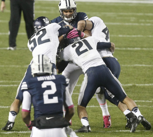 Chris Detrick  |  The Salt Lake Tribune
Brigham Young Cougars tight end Kaneakua Friel (82) is tackled by Utah State Aggies linebacker Kyler Fackrell (52) Utah State Aggies safety Brian Suite (21) and Utah State Aggies linebacker Cade Cowdin (45) during the first half of the game at LaVell Edwards Stadium Friday October 5, 2012. BYU is winning the game 6-3.