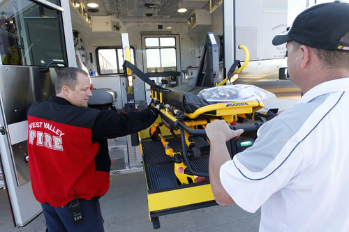 Al Hartmann  |  The Salt Lake Tribune
Cpt. Mark Ownsbey, of the West Valley City Fire Department, left, and fleet manager Eric Madsen, lower a stretcher lift system the department's new combination fire engine/ambulance.  The lift makes it easier to put patients in the vehicle.