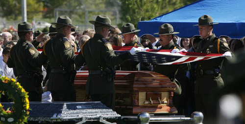 Francisco Kjolseth  |  The Salt Lake Tribune
U.S. Customs and Border Patrol agents fold the flag over the casket of border patrol agent Nicholas Ivie after arriving at the Spanish Fork Cemetery surrounded by friends, family, and numerous service agencies on Thursday, October 11, 2012.