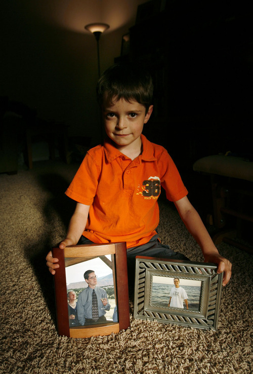 Steve Griffin  |  The Salt Lake Tribune

Salt Lake City - Ian Burns holds pictures of his father, Michael, from 1999, in his home in Murray Wednesday Jun 30, 2010.  Michael died after cancer treatment in 2001. Before undergoing therapy, Michael stored sperm because the treatments made him sterile. After he died, Gayle Burns, Michaels wife, conceived Ian who was born in 2003. She is fighting to get Ian recognized as MIchael's son so he can receive Social Security survivor's benefits. The case is at the Utah Supreme Court, and is the first case of its type in the state. The issue has also been raised in other states.  Wednesday Jun 30, 2010.