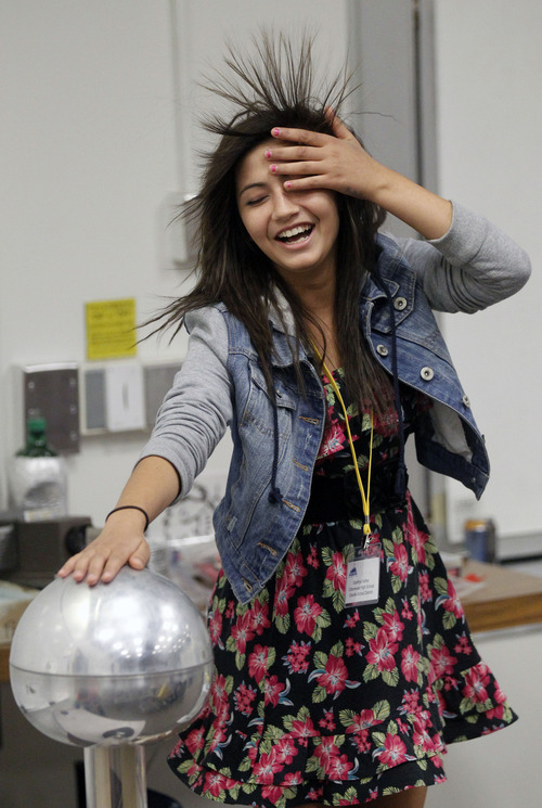 Al Hartmann  |  The Salt Lake Tribune
Cottonwood High School student Sandia Kafley's hair stands on end during a physics static electricity experiment given by University of Utah lecture demonstration specialist Adam Beehler during the 2nd annual Refugee Youth Conference that brought together more than 200 refugee students from Granite, Canyons and Salt Lake school districts to learn about the importance of education, particularly higher education.