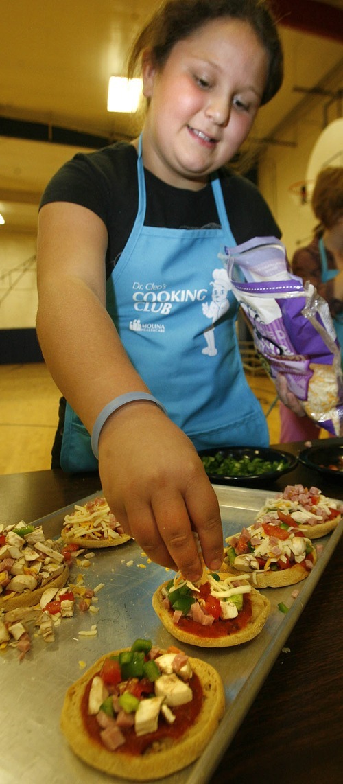 Paul Fraughton | The Salt Lake Tribune
 Chloi Langi, 9, puts cheese on top of her healthy English muffin pizzas at a cooking class sponsored by Molina Health Care at the Murray Boys and Girls Club on Oct. 1, 2012.