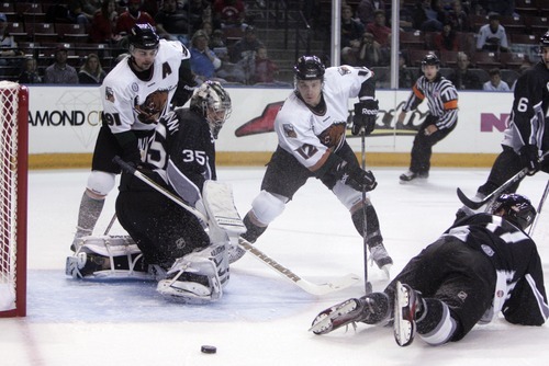 Kim Raff | The Salt Lake Tribune
Utah Grizzlies players (left) Riley Armstrong and (right) Bryan Cameron miss a shot at goal as Idaho Steelheads goalie Tyler Beskorowany looks on during the Grizzlies home opener at the Maverick Center in West Valley City, Utah on October 13, 2012.