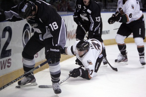 Kim Raff | The Salt Lake Tribune
(right) Utah Grizzlies player Mitch Wahi slides on the ice for the puck under  Idaho Steelheads player Andrew Wright's skates during the Grizzlies' home opener at the Maverick Center in West Valley City, Utah on October 13, 2012.