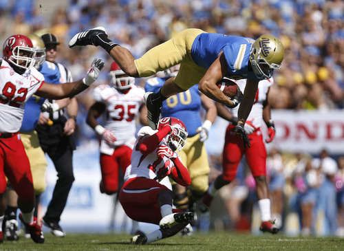 Scott Sommerdorf  |  The Salt Lake Tribune             
UCLA Bruins tight end Joseph Fauria (8) is knocked flying by a hit by Utah Utes defensive back Eric Rowe (18) during first half play. Utah plays UCLA in Pasadena, Saturday, October 13, 2012.