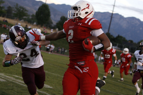 Chris Detrick  |  The Salt Lake Tribune
East's Ula Tulutau runs past Jordan's Cooper Clark for a touchdown during a game at East High School on Aug. 31, 2012.