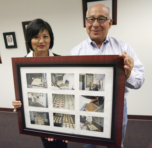 Steve Griffin | The Salt Lake Tribune
Susan and Gene Tafoya hold a frame with historic photos of Morrison Meat Pies being made. The Tafoya's own the company now and have moved into a new building in West Jordan, Utah Thursday September 20, 2012.