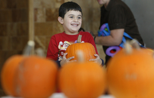 Scott Sommerdorf  |  The Salt Lake Tribune              
Christian Flores, 6, beams after choosing his pumpkin as children at the Kauri Sue Hamilton School in Riverton got a special Halloween delivery from an unlikely source, Monday, Oct. 21, 2012. More than 3,500 pumpkins harvested, gathered, and cleaned by Utah State Prison inmates in the Utah State Prison's Greenhouse program were donated to various organizations that serve children.