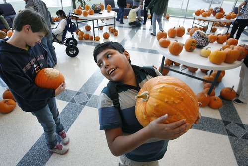 Scott Sommerdorf  |  The Salt Lake Tribune              
Parker Overton, 15, hefts his heavy pumpkin as children at the Kauri Sue Hamilton School in Riverton got a special Halloween delivery from an unlikely source, Monday, Oct. 21, 2012. More than 3,500 pumpkins harvested, gathered, and cleaned by Utah State Prison inmates in the Utah State Prison's Greenhouse program were donated to various organizations that serve children.