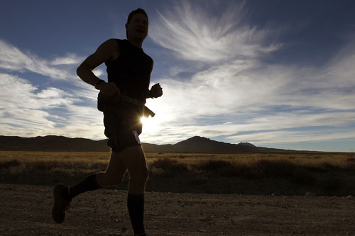 Al Hartmann  |  The Salt Lake Tribune
A runner breaks through the shadows as the sun rises in the early miles of the Pony Express Trail 100 Endurance Run Friday, Oct. 19.   Some 75 entrants and their support teams will run the 50-mile course or the 100-mile course along the historic Pony Express route in the west desert areas of Tooele and Juab counties.