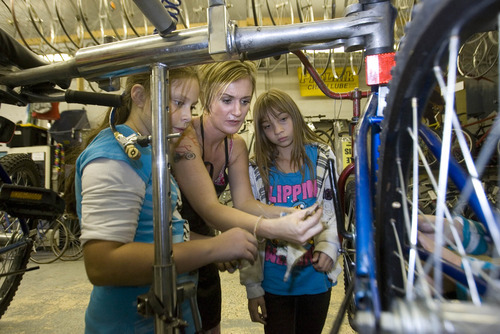 Paul Fraughton | The Salt Lake Tribune
Hailey Broussard, center, shows Cianne Paul, left, and Angel Martinez how to remove the lower bracket on a bicycle.