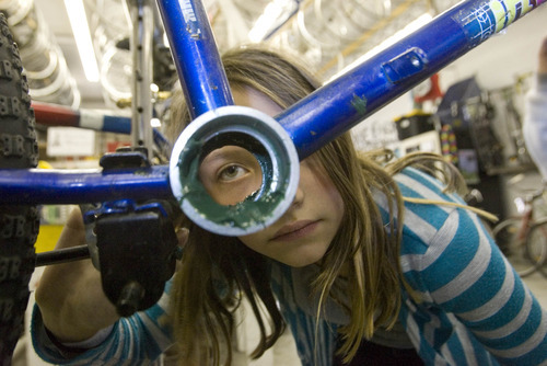 Paul Fraughton | The Salt Lake Tribune
Katie Johnson, 10, takes a close look at her work as she and her friends work at the Bicycle Collective.