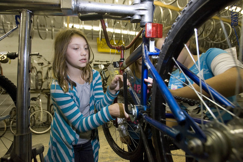 Paul Fraughton | The Salt Lake Tribune
Katie Johnson uses a wrench to remove the bottom bracket of a bike  so she and her team can repack it  with grease.
