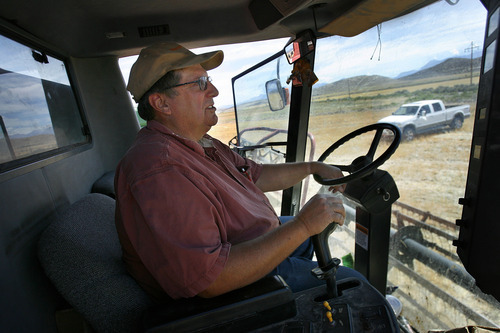Scott Sommerdorf  |  The Salt Lake Tribune             
Jim Smith sits in a wheat harvester, Monday, July 23, 2012. Smith, a dry land wheat farmer in Cedar Valley, is owed money by the Lehi Roller Mills, but says he'll wait out payment because of the Mills' importance to local farmers. Smith's family has been doing business with the Roller Mills since 1916.